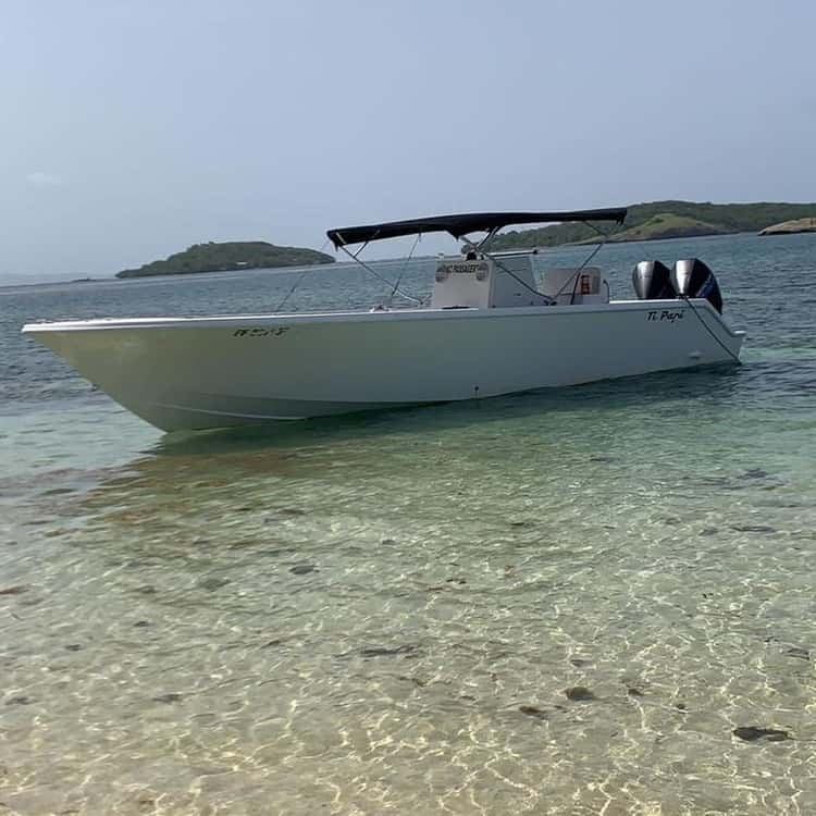 Bateau Ti Papi ancré dans une eau turquoise peu profonde
